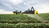 Photo of farmland with John Deere sprayer featuring See & Spray technology